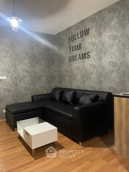 Modern living room with stylish black sofa and motivational wall art