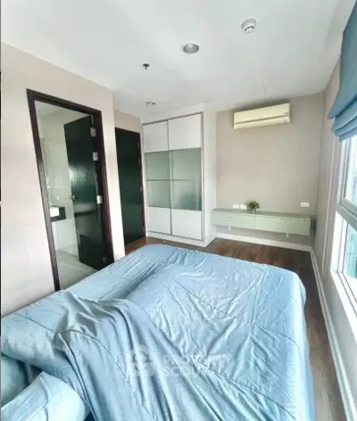 Bright and cozy bedroom with modern furnishings and large window view.