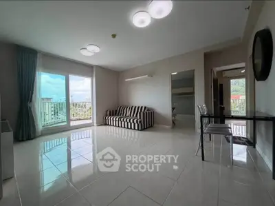 Spacious modern living room with large windows and stylish furniture in a bright apartment.