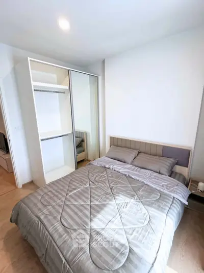 Modern bedroom with sleek wardrobe and cozy bedding in a stylish apartment.
