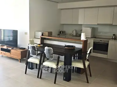 Modern open-layout kitchen and dining area with sleek appliances and stylish furniture.