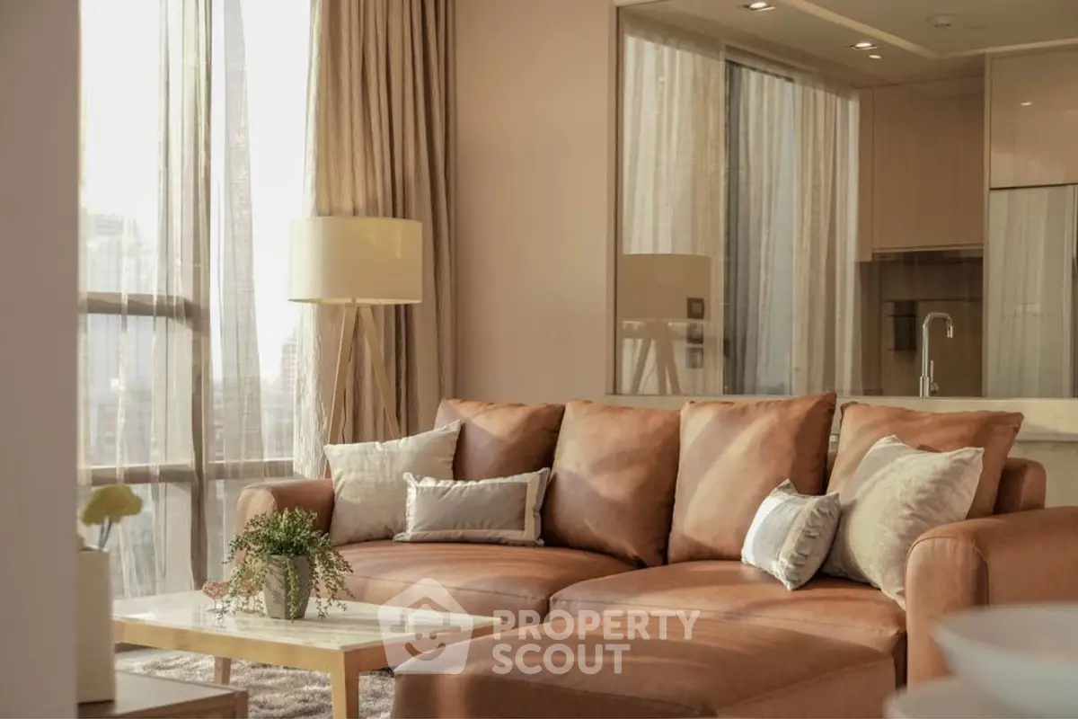 Luxurious living room with elegant leather sofa and large windows offering natural light.