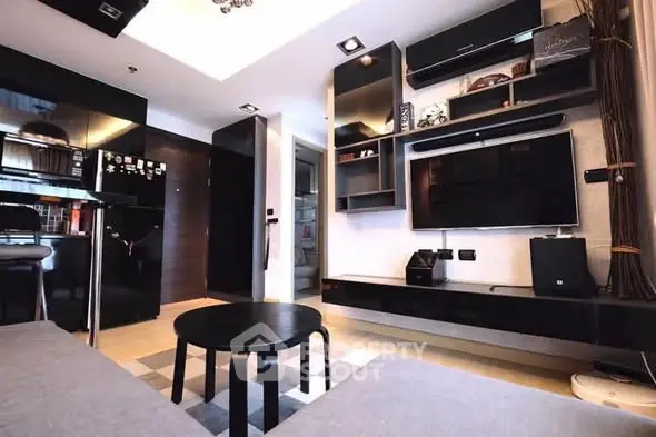Modern living room with sleek black furniture and wall-mounted TV