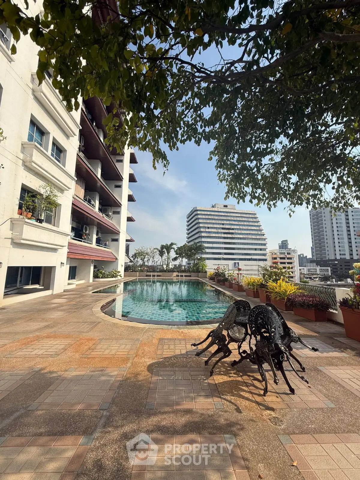 Stunning rooftop pool with city views and lush greenery in a modern building.