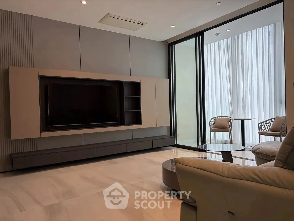 Luxurious modern living room with sleek design and large windows opening to a stylish balcony.