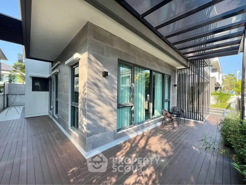 Modern house exterior with spacious wooden deck and large windows