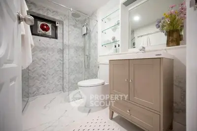 Modern bathroom with glass shower and elegant vanity in stylish home.