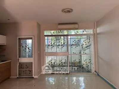 Spacious living room with decorative window grills and air conditioning