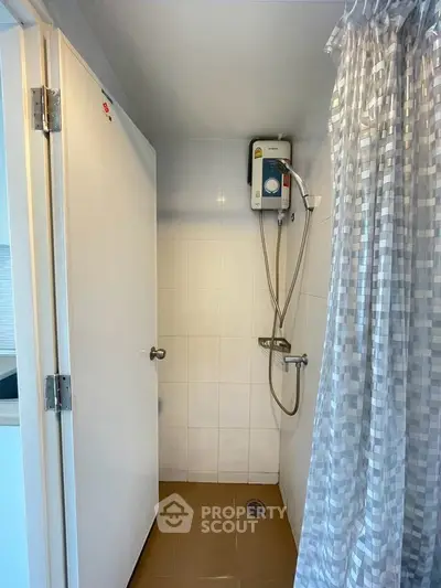 Compact bathroom with shower and water heater, ideal for modern living spaces.
