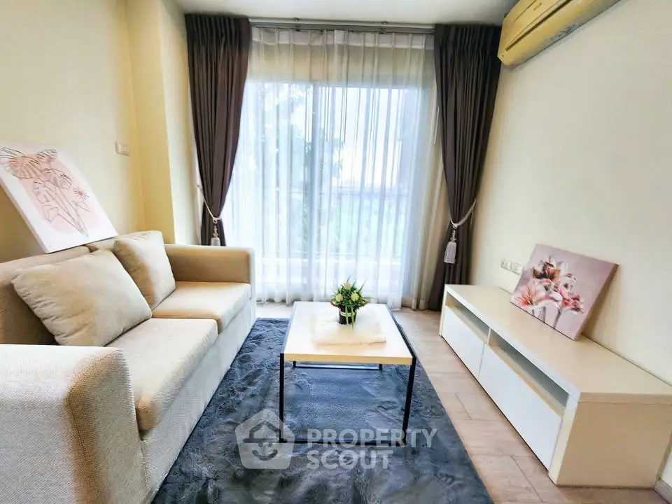 Cozy living room with modern decor and large window for natural light.