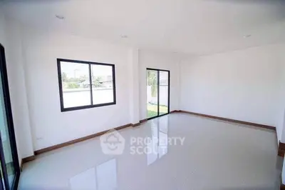 Spacious and bright empty living room with large windows and glossy tiled floor.