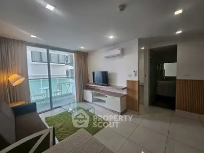 Modern living room with balcony, featuring sleek furniture and ample natural light.