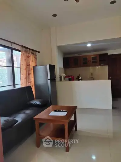 Cozy living room with open kitchen and natural light