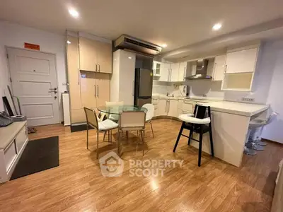 Modern open-layout kitchen with dining area and sleek appliances in a cozy apartment.