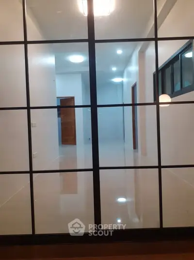 Spacious modern hallway with sleek glass partition and elegant lighting