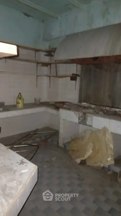 Rustic kitchen space with vintage tiles and open shelving, ideal for renovation.