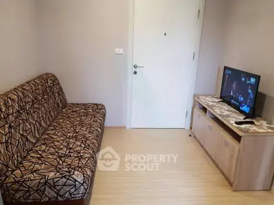 Cozy living room with patterned sofa and flat-screen TV, perfect for relaxation.
