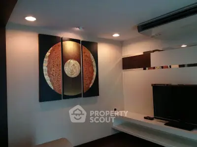 Modern living room with stylish wall art and sleek TV setup, perfect for contemporary living.