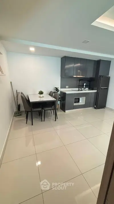 Modern kitchen with sleek cabinets and dining area in contemporary apartment