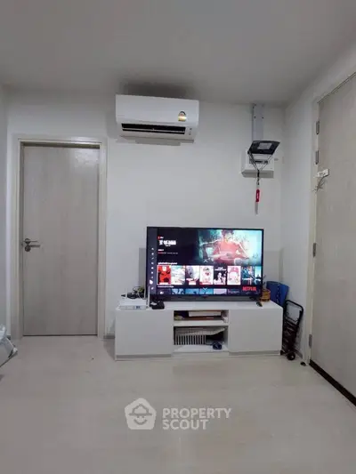 Modern living room with sleek TV setup and air conditioning unit