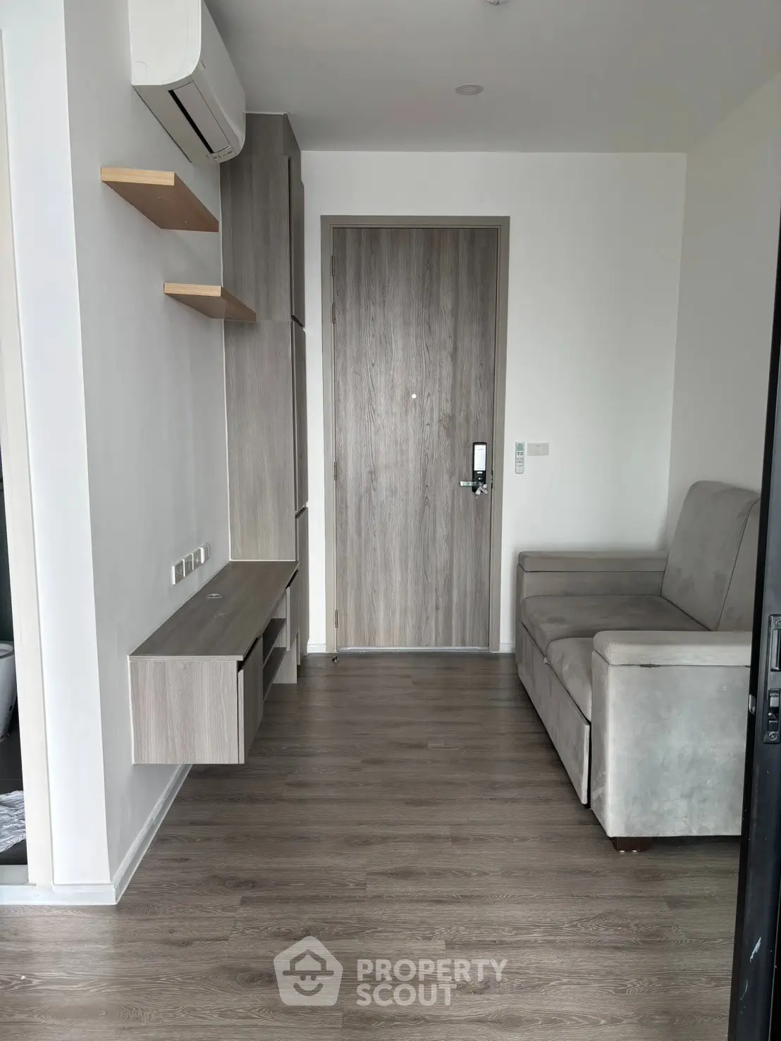 Modern living room with sleek furniture and wooden flooring in a contemporary apartment.