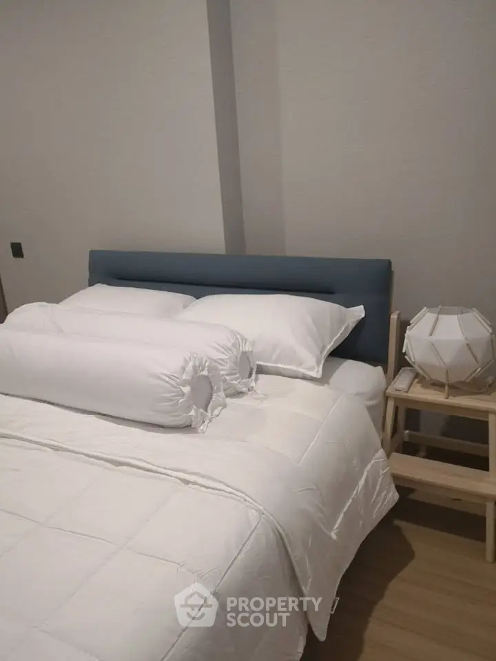 Cozy bedroom with modern decor and stylish lighting, perfect for relaxation.