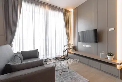 Modern living room with sleek design, large window, and stylish furniture in a contemporary apartment.