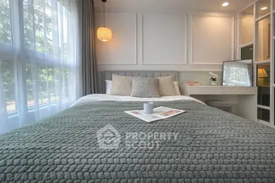 Cozy bedroom with large window and stylish decor, perfect for relaxation and comfort.