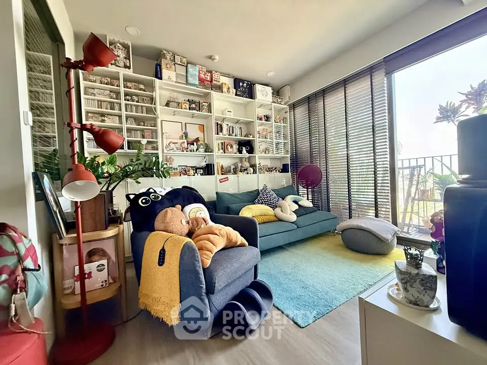 Cozy living room with modern decor and large windows leading to a balcony.