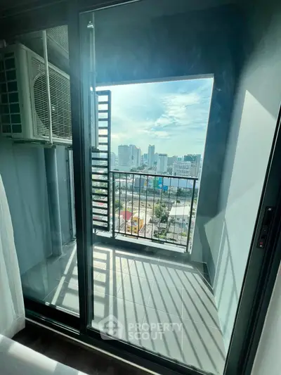 Modern apartment balcony with city view and air conditioning unit, perfect for urban living.