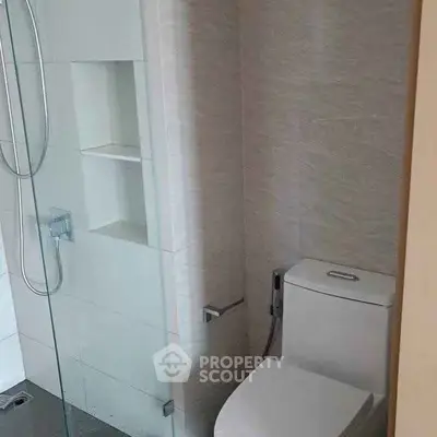 Modern bathroom with glass shower and sleek toilet design.