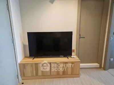 Modern living room with sleek TV stand and flat-screen TV, perfect for entertainment.