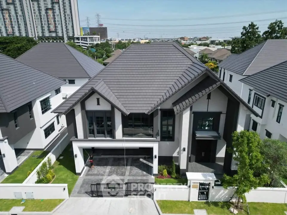 Luxurious modern house with sleek design and spacious driveway in upscale neighborhood.