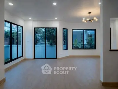 Spacious modern living room with large windows and elegant lighting