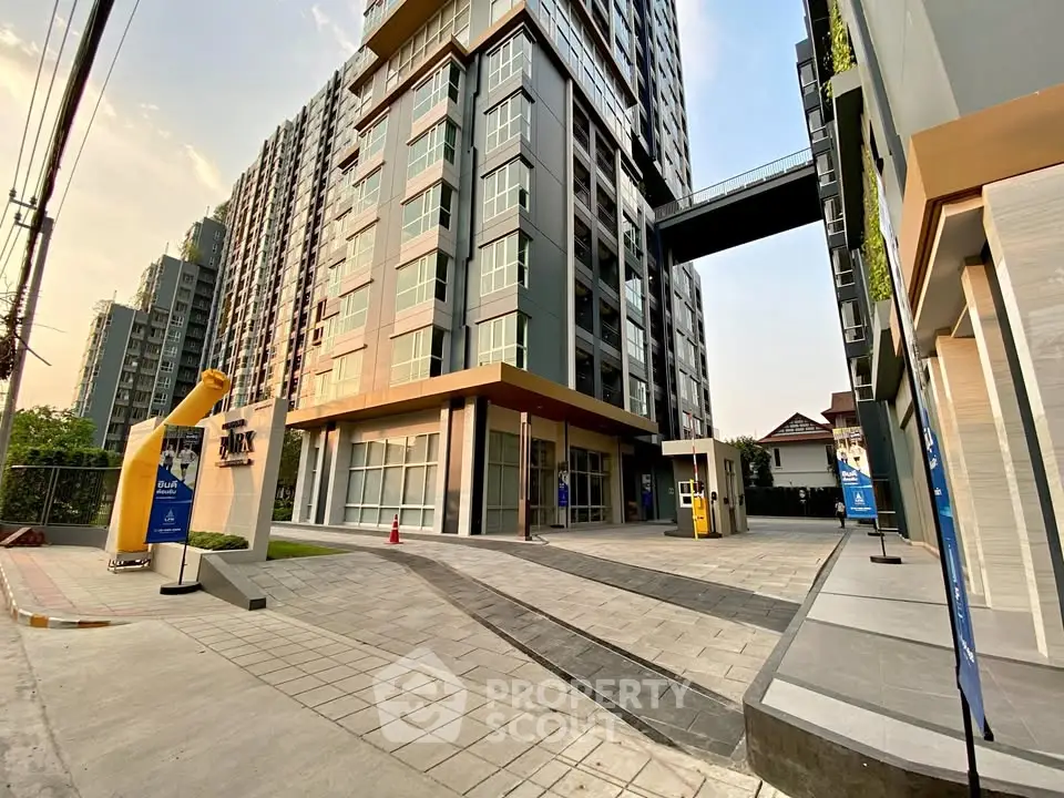 Modern high-rise condominium building with sleek architecture and spacious entrance.