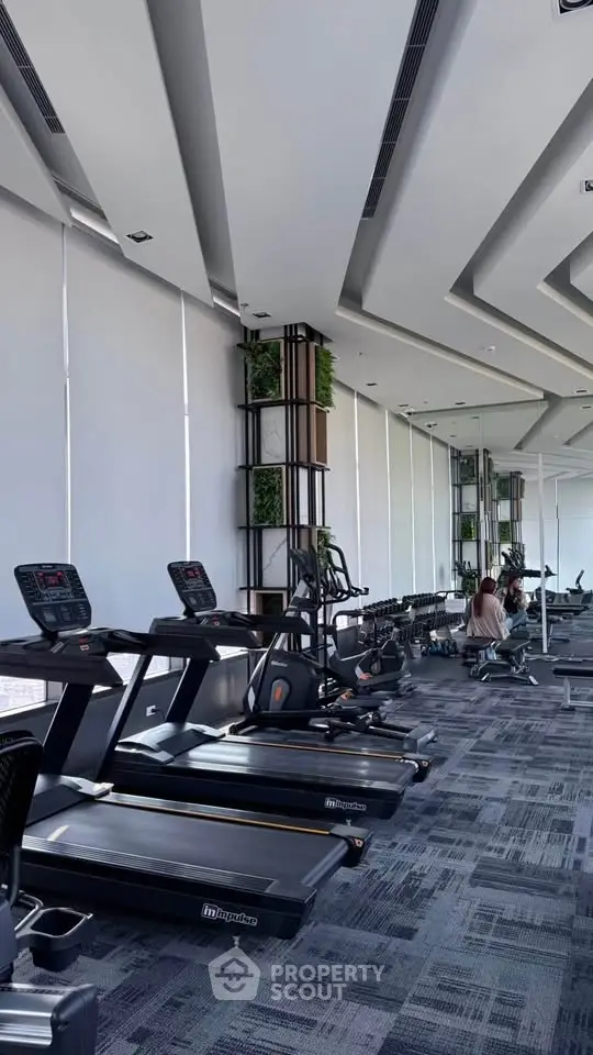 Modern gym with state-of-the-art equipment and large windows for natural light.