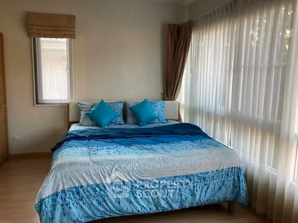 Cozy bedroom with large windows and stylish blue bedding