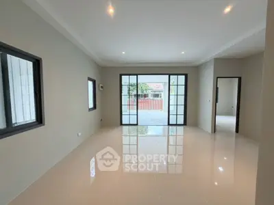 Spacious modern living room with large windows and glossy tiled floor