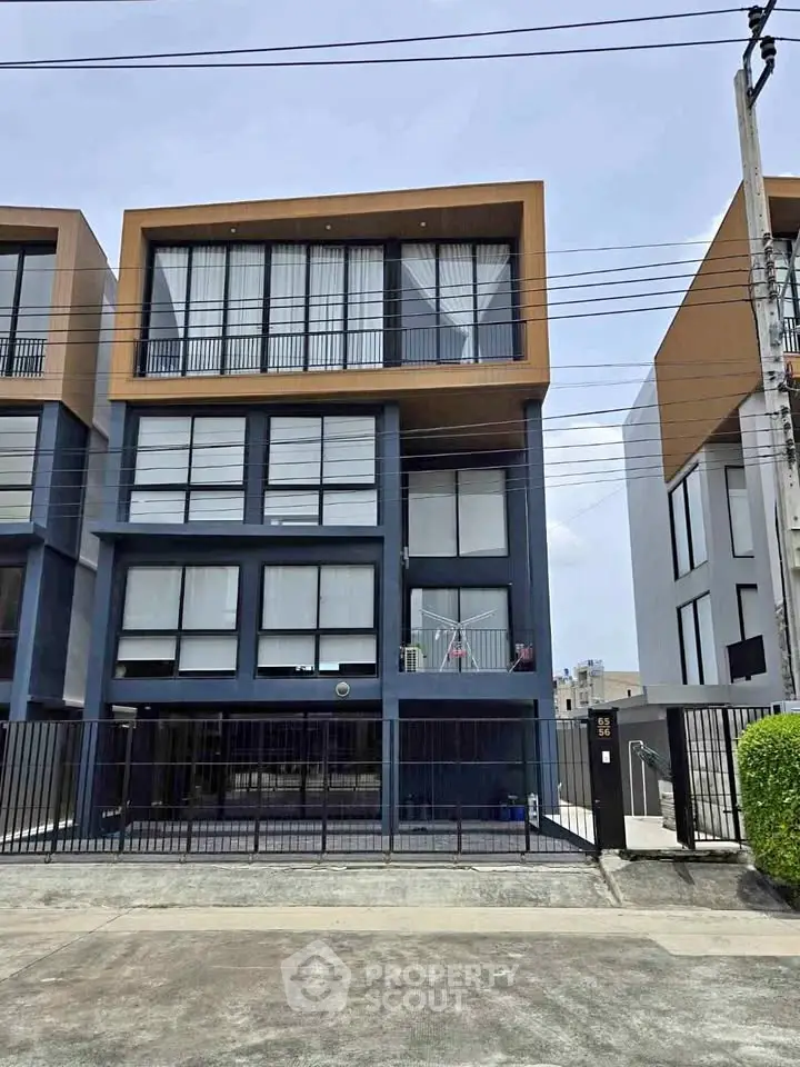 Modern multi-story building with large windows and sleek design in urban setting.