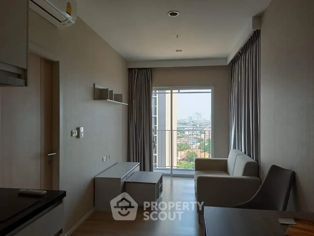 Modern living room with sleek furniture and ample natural light, featuring a large window with a city view, perfect for urban living.