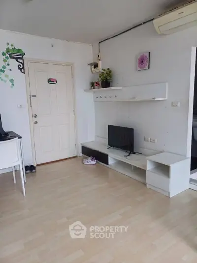 Modern living room with minimalist decor and wall-mounted TV in a cozy apartment.