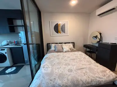 Cozy bedroom with modern decor and adjacent kitchen area in a stylish apartment.