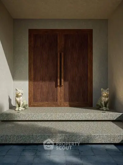 Elegant entrance with wooden double doors and decorative cat statues on stone steps.