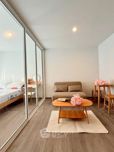 Modern living room with cozy sofa, wooden coffee table, and elegant decor in a bright, minimalist space.