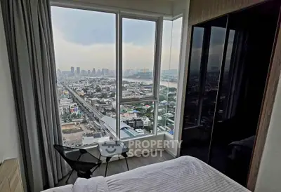 Stunning high-rise bedroom with panoramic city view and modern furnishings.