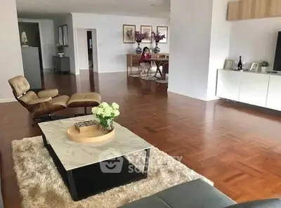 Spacious living room with elegant parquet flooring and modern furniture.