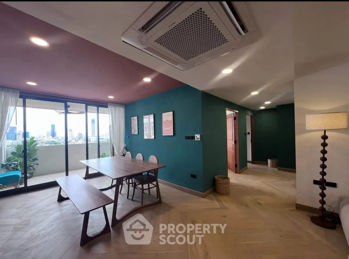 Spacious modern living room with balcony and city view, featuring stylish decor and ample natural light.