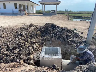 Construction site with foundation work and nearby building structure