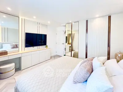 Luxurious modern bedroom with elegant decor and large TV