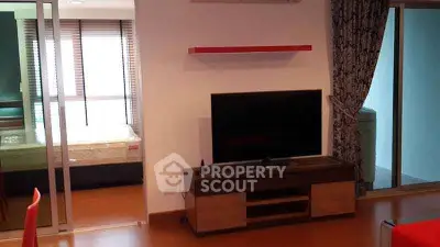 Modern living room with TV and sliding glass doors to balcony